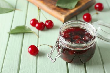 Renkli ahşap arka planda kiraz reçeli kavanozu