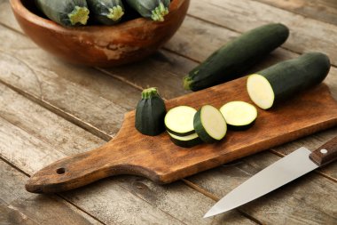 Tahta arka planda dilimlenmiş kabak kabağı olan tahta, yakın plan.