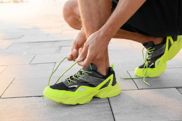 Sporty Young Man Tying Shoe Laces Outdoors — Stock Photo, Image