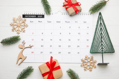 Hafif ahşap zemin üzerinde takvim bulunan Noel kompozisyonu
