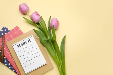 Çiçekli takvim ve renk arkaplanı üzerine not defterleri