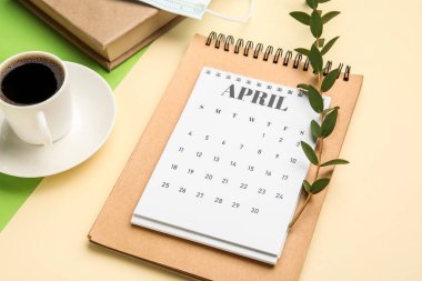 Renkli arka planda bir fincan kahve ve defter takvimi