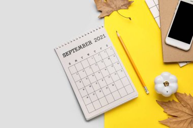 Cep telefonu, defter ve sonbahar yaprakları renk arkaplanında takvim