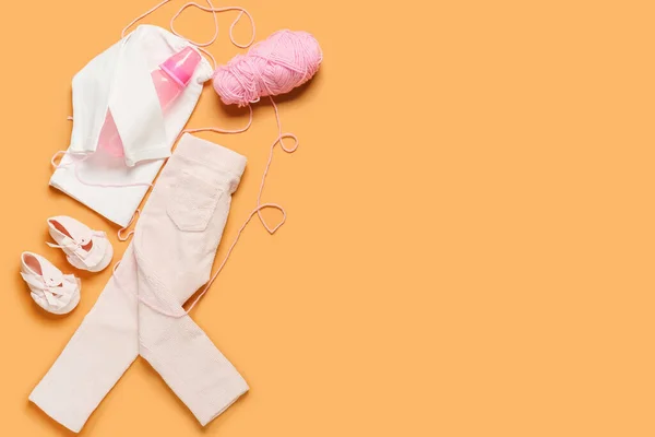 Stylische Babykleidung Mit Flasche Und Strickgarn Auf Farbigem Hintergrund — Stockfoto