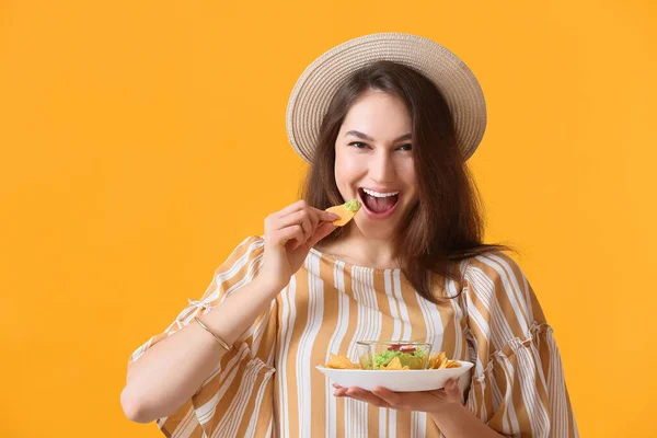 Beautiful Young Woman Eating Tasty Nachos Color Background — Stock Photo, Image