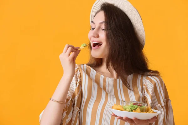 Beautiful Young Woman Eating Tasty Nachos Color Background — Stock Photo, Image