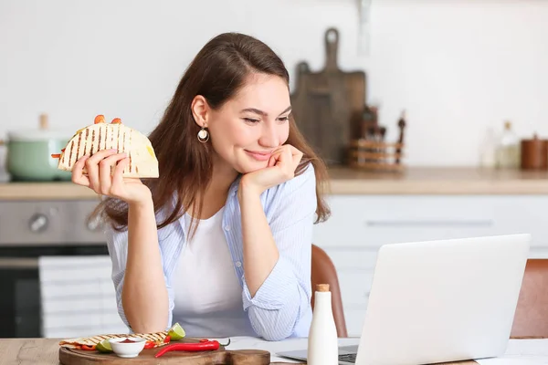 Dizüstü Bilgisayarı Olan Güzel Genç Bir Kadın Evde Lezzetli Quesadilla — Stok fotoğraf