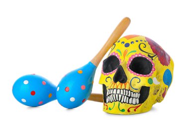 Meksika Ölüler Günü için boyanmış insan kafatası (El Dia de Muertos) ve beyaz arka planda marakas