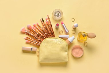 Renkli arka planda şık çanta ve dekoratif kozmetik