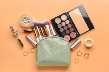 Renkli arka planda şık çanta ve dekoratif kozmetik