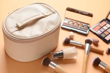 Renkli arka planda şık çanta ve dekoratif kozmetik, yakın plan