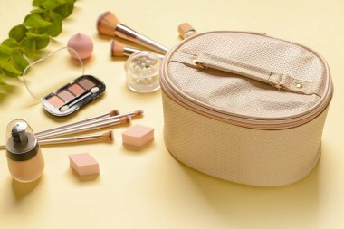 Renkli arka planda şık çanta ve dekoratif kozmetik, yakın plan