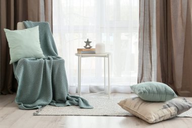 Ekoseli sandalye ve pencere kenarındaki masa.