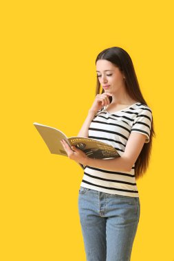 Renkli dergisi olan güzel bir genç kadın.