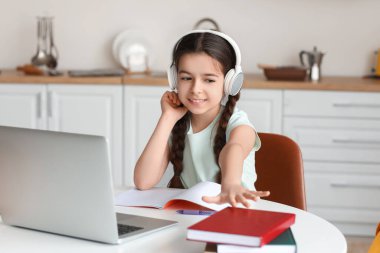 Küçük kız evde online çalışıyor.