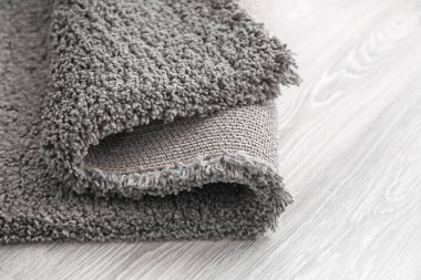 Ahşap zeminde gri halı, yakın plan.