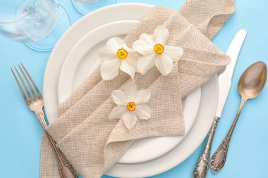 Renk arkaplanında narsisus çiçekleri olan güzel masa ayarları