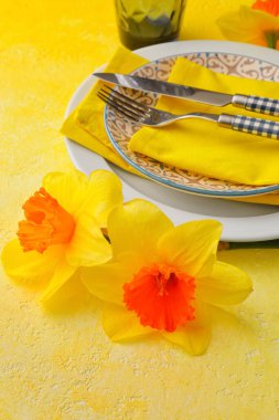 Renk arkaplanında narsisus çiçekleri olan güzel masa ayarları