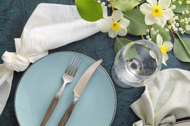 Koyu arkaplanda narsis çiçekleri olan güzel bir masa.