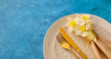 Renk arkaplanında narsisus çiçekleri olan güzel masa ayarları