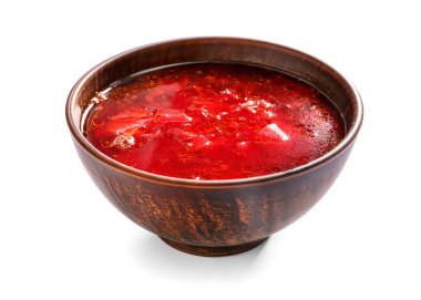 Beyaz arkaplanda lezzetli borş çorbası olan bir kase.