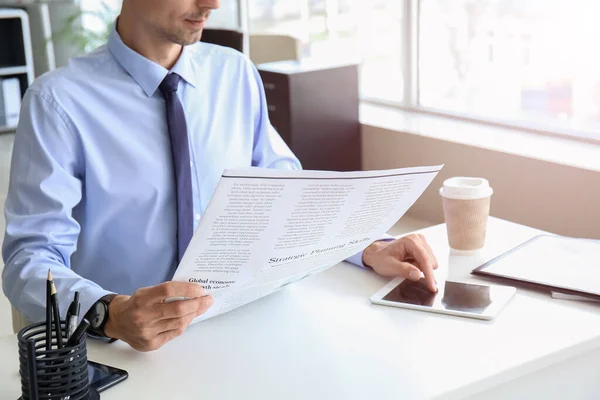 Junger Geschäftsmann Liest Zeitung Während Tablet Computer Büro Benutzt — Stockfoto
