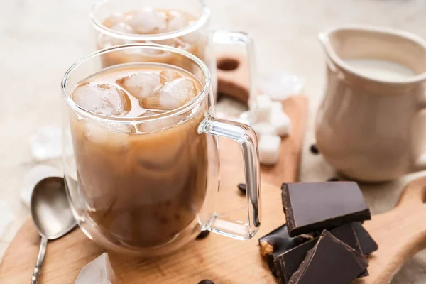 テーブルの上においしいアイスコーヒーとチョコレートのガラスカップと木製のボード クローズアップ — ストック写真