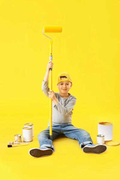 Kleiner Junge Mit Rolle Und Farbdosen Auf Farbigem Hintergrund — Stockfoto