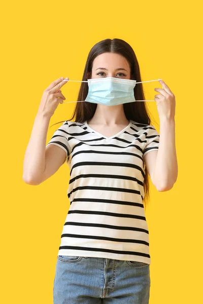 Jovem Mulher Colocando Máscara Médica Contra Fundo Cor — Fotografia de Stock