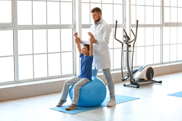 Physiotherapist working with boy in rehabilitation center