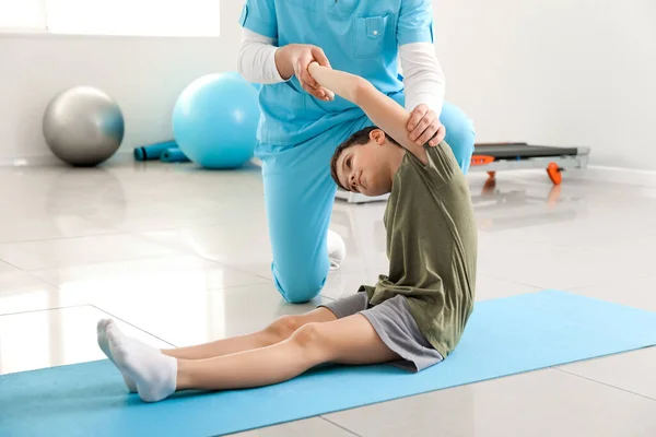 Physiotherapist working with boy in rehabilitation center