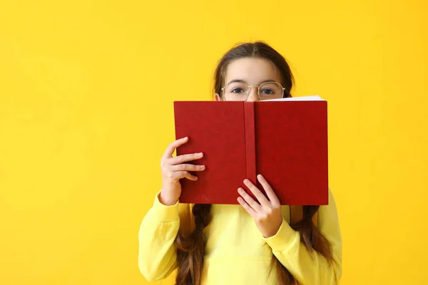 Nettes Kleines Schulmädchen Mit Buch Auf Farbigem Hintergrund — Stockfoto