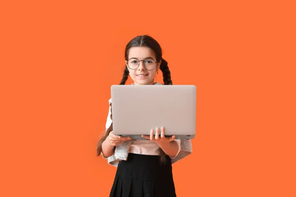 Nettes Kleines Schulmädchen Mit Laptop Auf Farbigem Hintergrund — Stockfoto