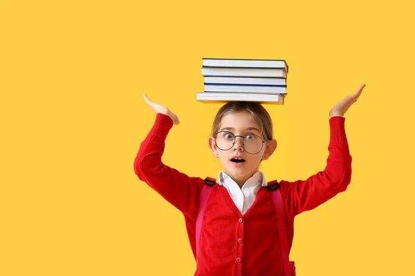 Geschokt Klein Schoolmeisje Met Boeken Hoofd Tegen Kleur Achtergrond — Stockfoto