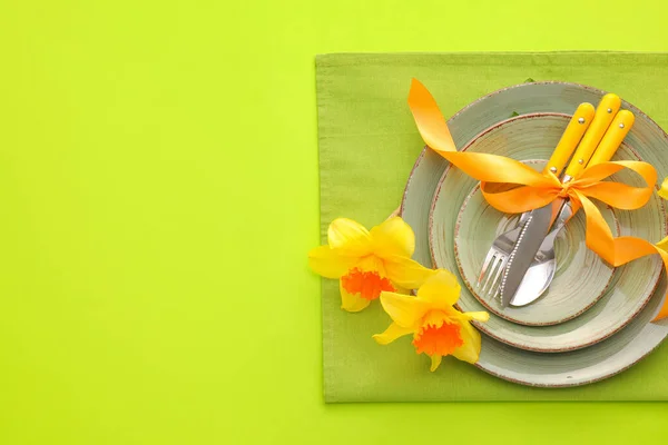 美しいテーブル設定ともにナルシシズム花の上の色の背景 — ストック写真