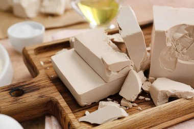 Masanın üzerinde taze maya briketleri olan ahşap tahta bir tahta.