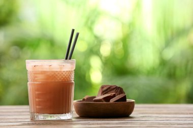 Dışarıdaki masada bir bardak lezzetli çikolatalı süt, yakın plan.