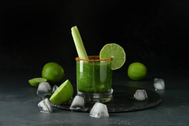 Arka planda bir bardak Bloody Mary kokteyli.