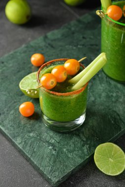 Arka planda bir bardak Bloody Mary kokteyli.