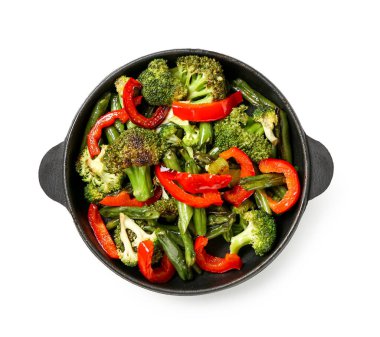 Beyaz arka planda farklı sebzelerle kızartma tavası