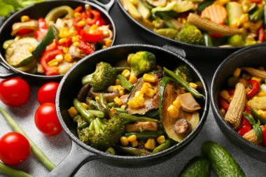 Hafif arka planda farklı sebzelerle kızartma tavaları, yakın plan