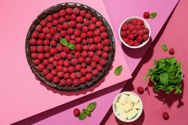 Renkli arkaplanda lezzetli ahududu turtası, nane ve tereyağı olan tahta