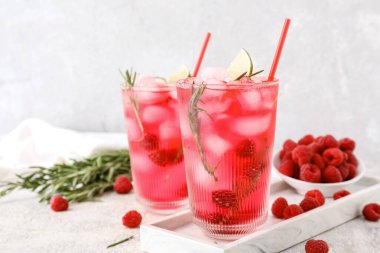 Bir bardak lezzetli ahududu limonata ve açık arkaplanda böğürtlen.