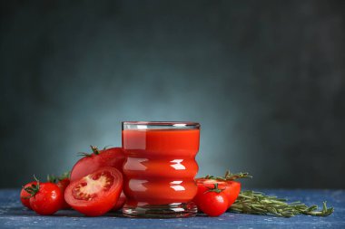 Koyu arkaplanda bir bardak lezzetli domates suyu.