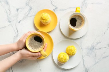 Kadınsı eller ve kahve fincanları ve grunge arka planda kekler.