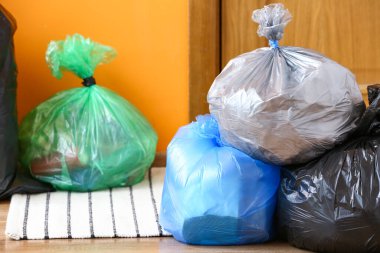 Kapının yanında çöp torbaları var.