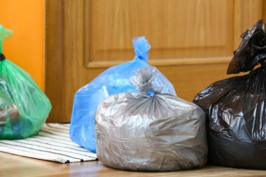 Kapının yanında çöp torbaları var.