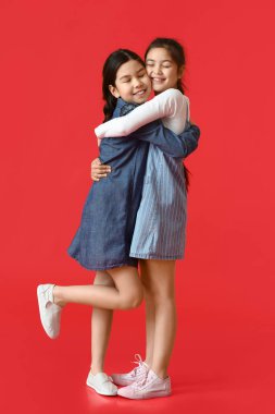 Renkli arka planda mutlu küçük kız kardeşler