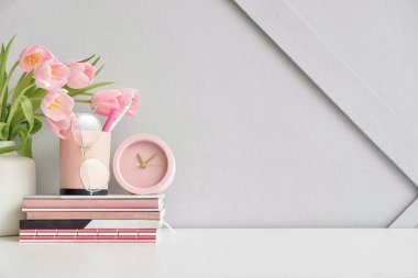 Not defterleri ve lale çiçekleriyle aydınlık duvarın yanında şık bir iş yeri