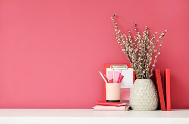 Renk duvarının yanında söğüt dalları ve kırtasiye malzemesi olan şık bir iş yeri